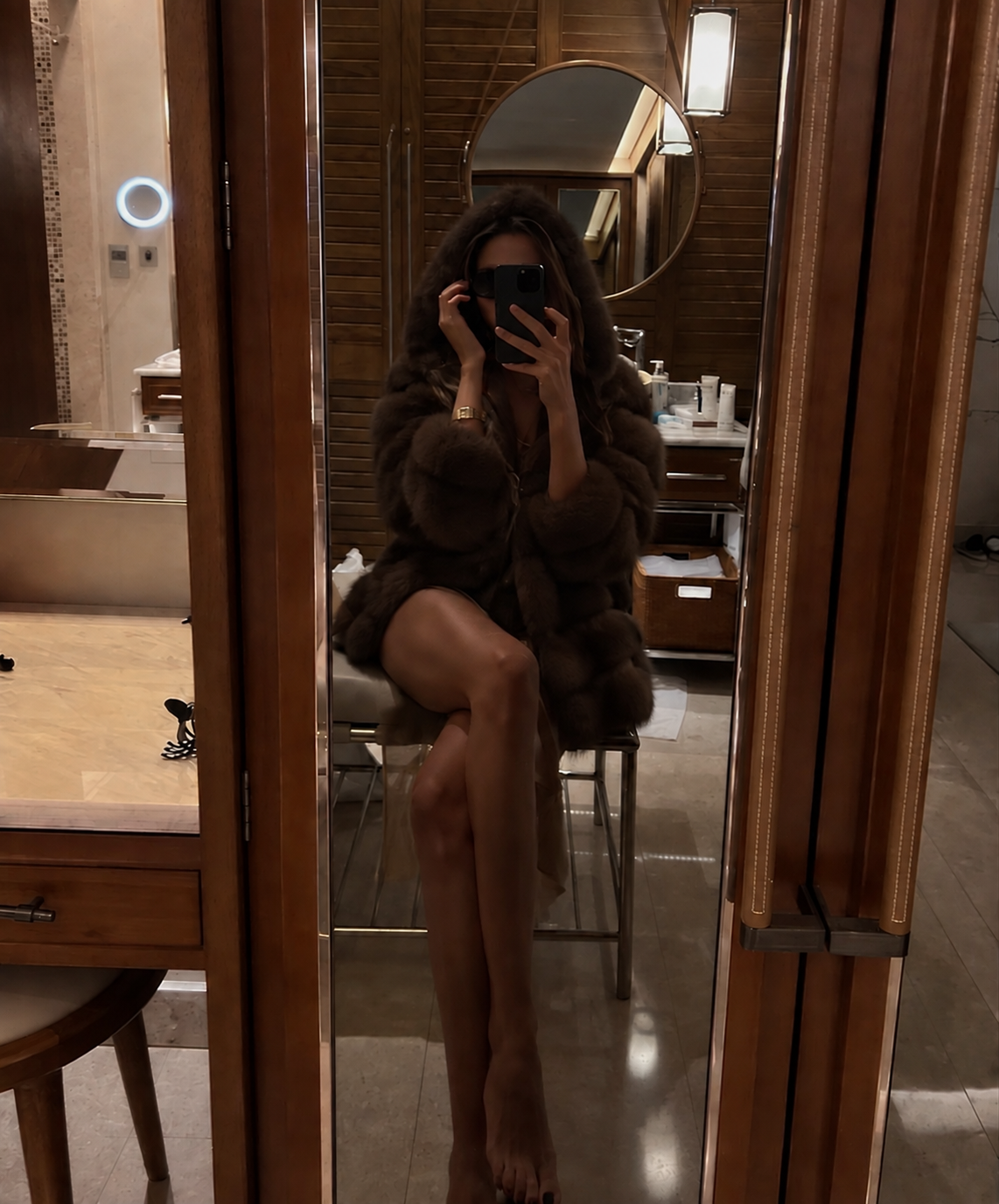 Mirror selfie in fur coat at luxury hotel bathroom